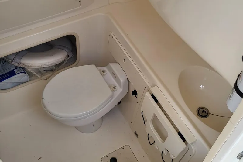 Slide: The Image of 2004 Boston Whaler 320 Outrage boat bathroom with toilet and sink. - 8