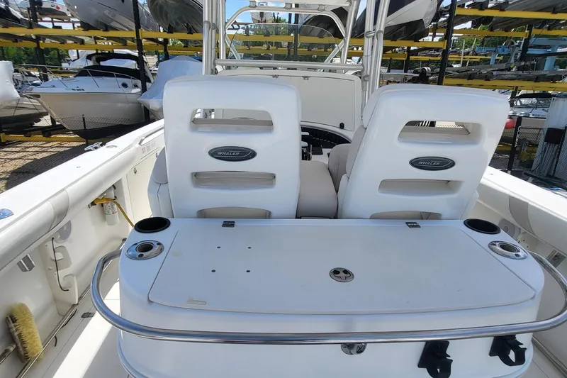 Slide: The Image of 2004 Boston Whaler 320 Outrage boat interior with dual seats and storage area. - 16