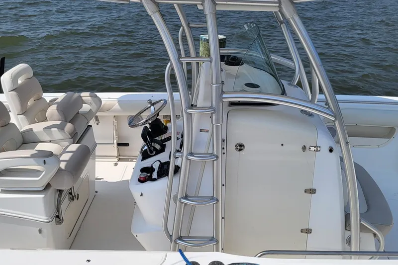 Slide: The Image of 2004 Boston Whaler 320 Outrage boat interior with helm and seating, on water. - 6