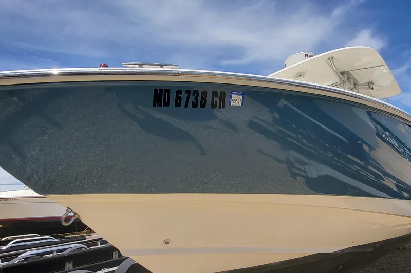 Slide: The Image of 2004 Boston Whaler 320 Outrage boat with registration MD 6738 CR, under a clear blue sky. - 4
