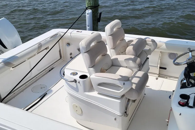 Slide: The Image of 2004 Boston Whaler 320 Outrage boat interior with cushioned seating and steering wheel. - 7