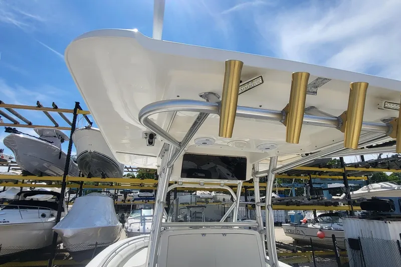 Slide: The Image of Boston Whaler 320 Outrage 2004 boat with rod holders, docked under clear blue sky. - 17