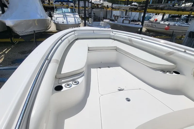 Slide: The Image of 2004 Boston Whaler 320 Outrage boat interior with seating and cup holders in a marina. - 12