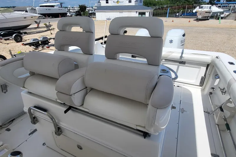 Slide: The Image of 2004 Boston Whaler 320 Outrage boat interior with cushioned seating and helm station. - 15