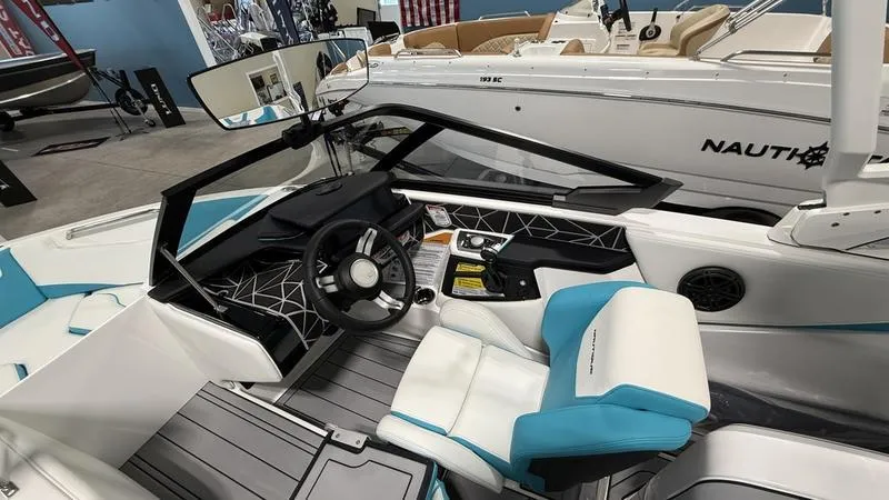 Slide: The Image of 2025 Nautique Ski 200 boat interior with modern dashboard and blue-accented seating. - 4