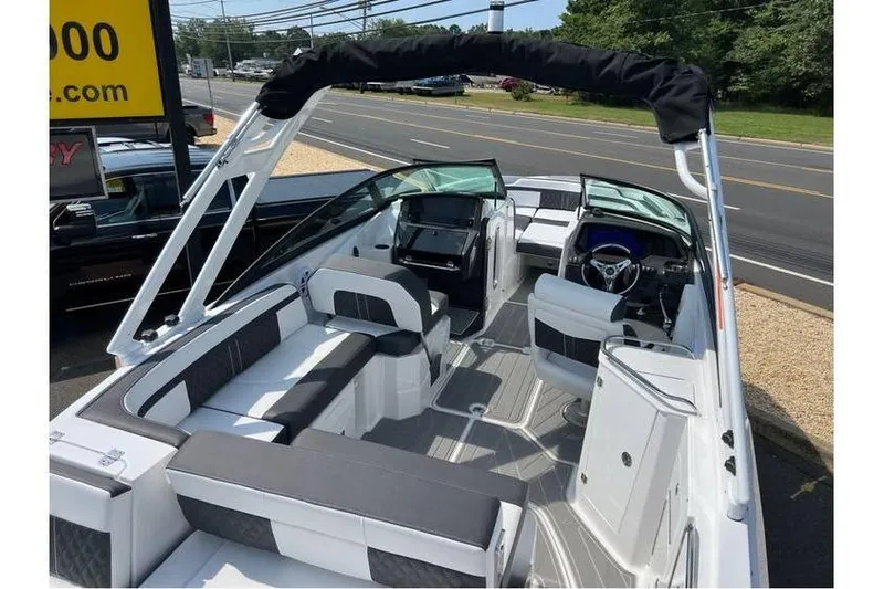 Slide: The Image of 2026 Monterey M-45 boat interior with seating and steering wheel, parked near a road. - 19
