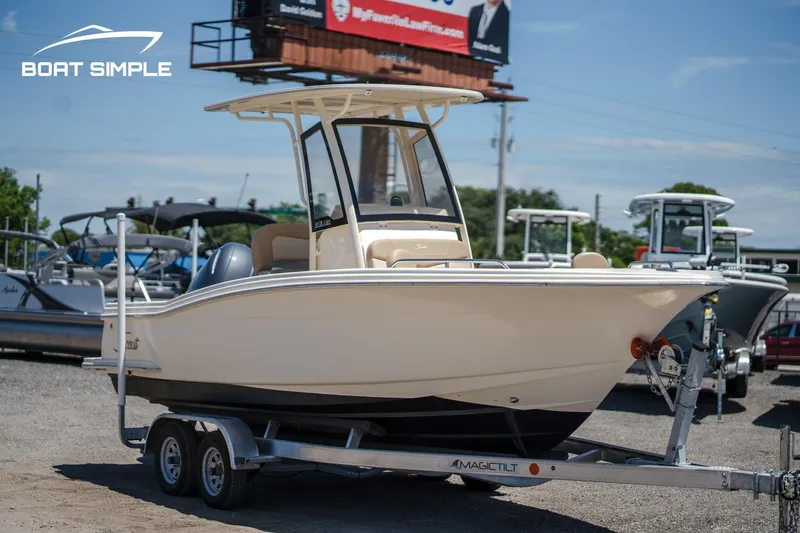 Slide: The Image of 2023 Scout 215 XSF boat on trailer in outdoor dealership lot. - 1