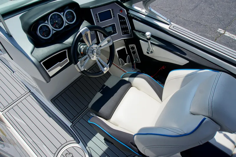 Slide: The Image of 2018 MasterCraft XT22 boat interior with steering wheel, dashboard, and captain's seat. - 10