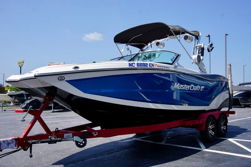 Slide: The Image of 2018 MasterCraft XT22 boat on red trailer in parking lot. - 6
