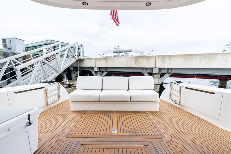 Slide: The Image of Luxury Maritimo M56 yacht deck with white seating, wooden flooring, and dockside view. - 25
