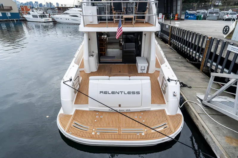 Slide: The Image of 2010 Maritimo M56 yacht docked, featuring teak deck and "Relentless" nameplate. - 26