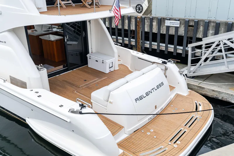 Slide: The Image of 2010 Maritimo M56 yacht docked, featuring teak deck and American flag. - 28