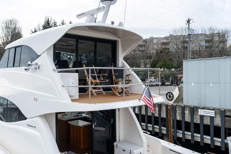 Slide: The Image of Luxury 2010 Maritimo M56 yacht docked, featuring upper deck seating and American flag. - 29