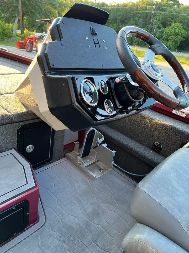 Slide: The Image of 2024 Avid 20 XB boat dashboard with steering wheel and gauges. - 16
