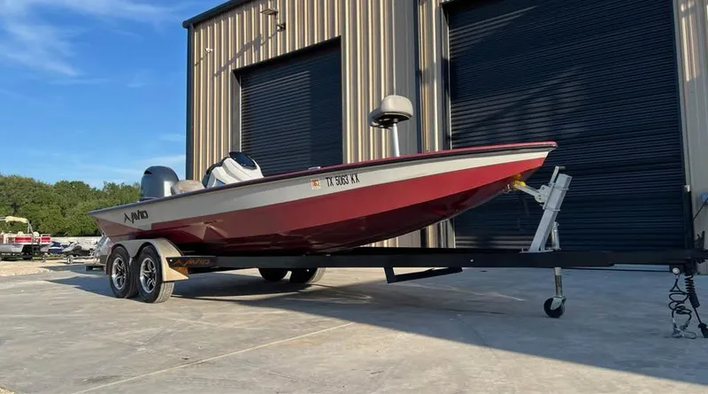 Slide: The Image of 2024 Avid 20 XB boat on trailer, parked outside a building. - 2