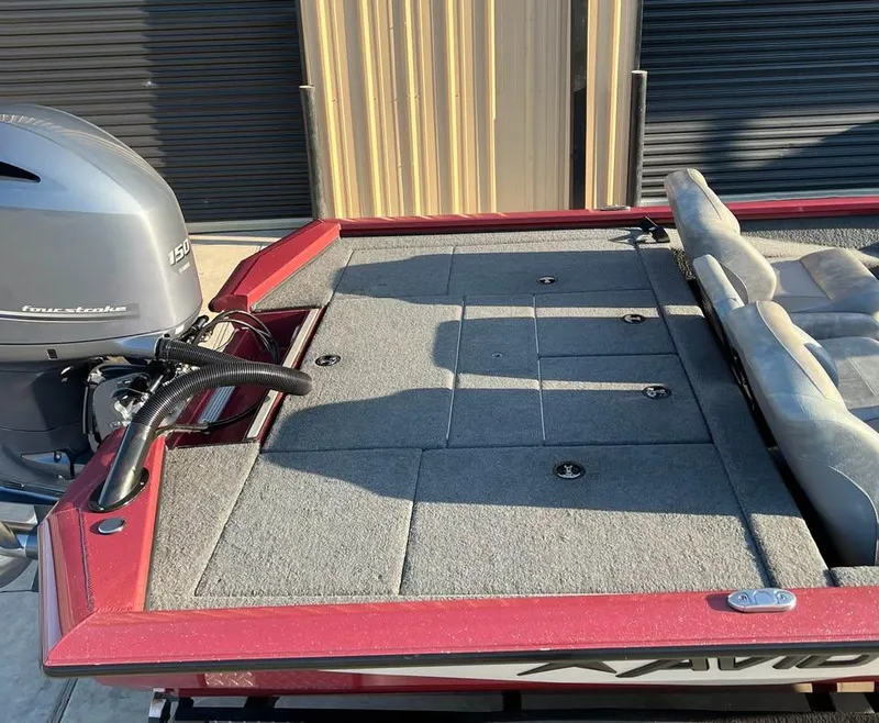 Slide: The Image of 2024 Avid 20 XB boat with four-stroke engine, red trim, and cushioned seating. - 5