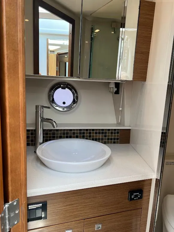 Slide: The Image of 2014 Cruisers Yachts 45 Cantius Black Diamond bathroom with modern sink and porthole window. - 44