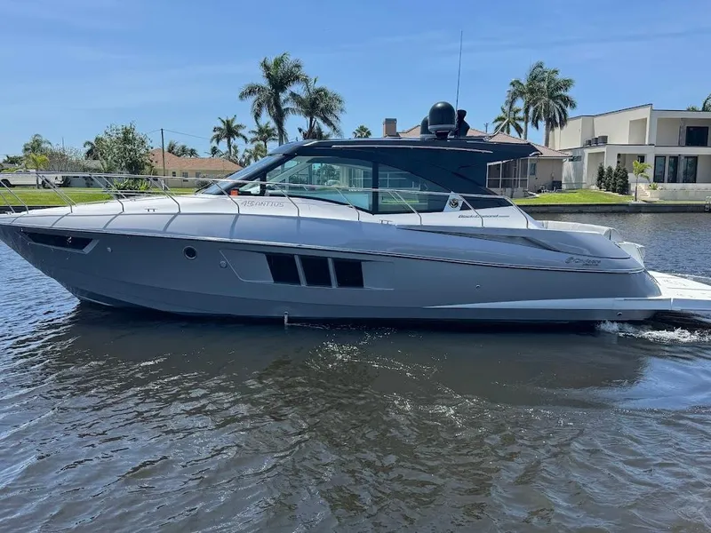Slide: The Image of 2014 Cruisers Yachts 45 Cantius Black Diamond on water, sleek design, palm trees in background. - 6