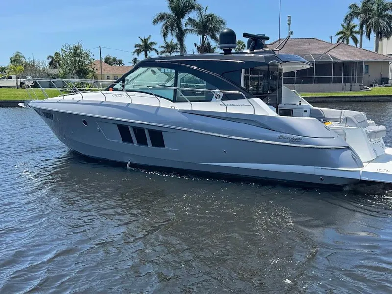 Slide: The Image of 2014 Cruisers Yachts 45 Cantius Black Diamond on water, sleek design, palm trees in background. - 7