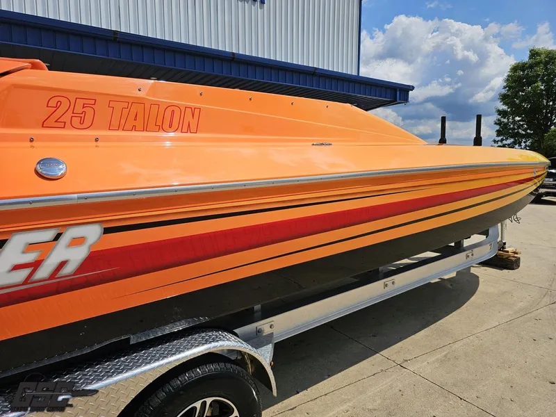 Slide: The Image of 2019 Hustler 25 Talon Cat boat in vibrant orange on a trailer, outdoors. - 10