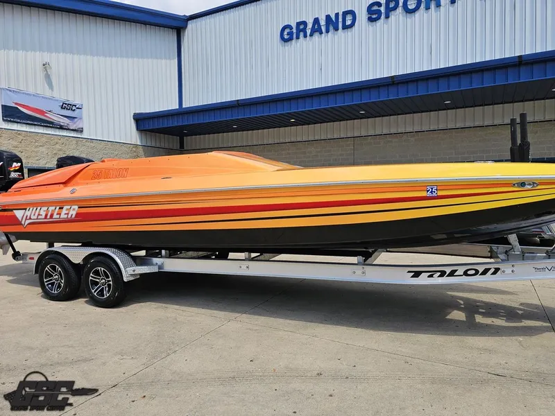 Slide: The Image of 2019 Hustler 25 Talon Cat boat with vibrant orange and yellow design on a trailer. - 15