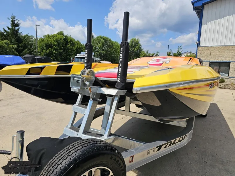 Slide: The Image of 2019 Hustler 25 Talon Cat boat on trailer, vibrant yellow and black design, outdoors. - 23