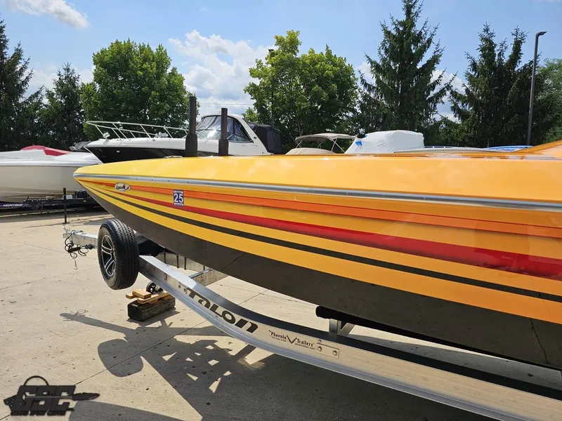 Slide: The Image of 2019 Hustler 25 Talon Cat boat on trailer, vibrant yellow and red design. - 30