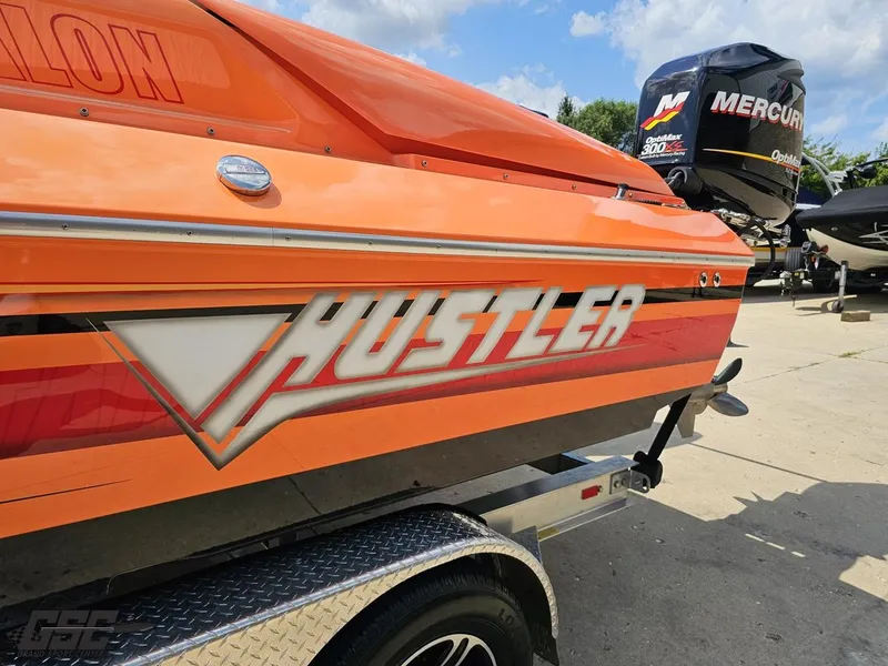Slide: The Image of 2019 Hustler 25 Talon Cat boat with Mercury engine, vibrant orange design. - 32