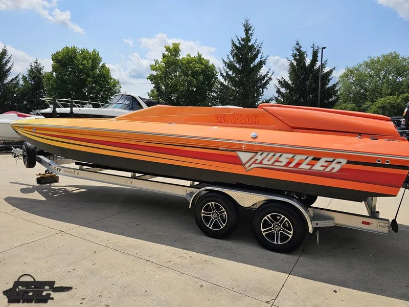 Slide: The Image of 2019 Hustler 25 Talon Cat speedboat on trailer, vibrant orange design, parked outdoors. - 35