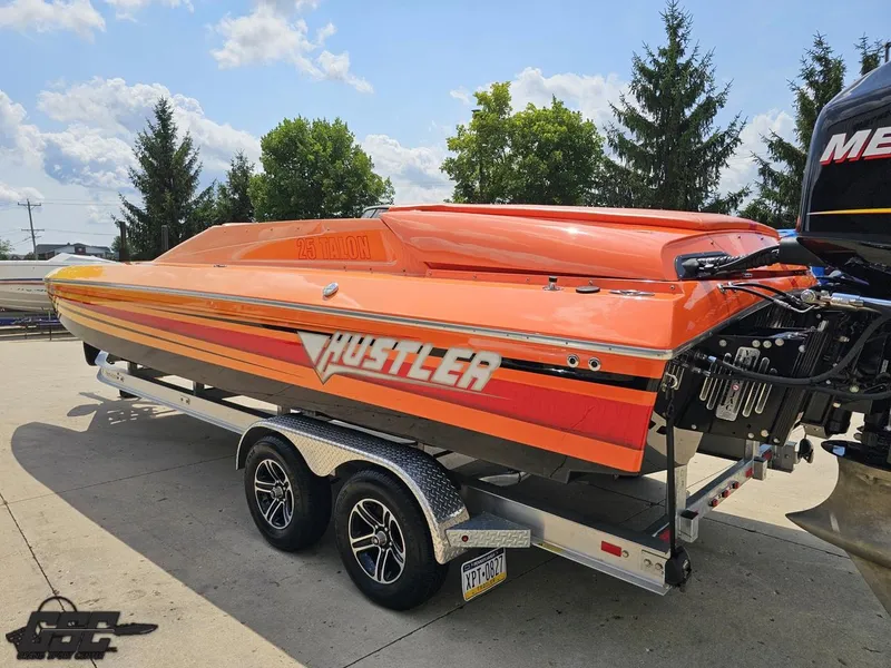 Slide: The Image of 2019 Hustler 25 Talon Cat boat in vibrant orange on a trailer, outdoors. - 36