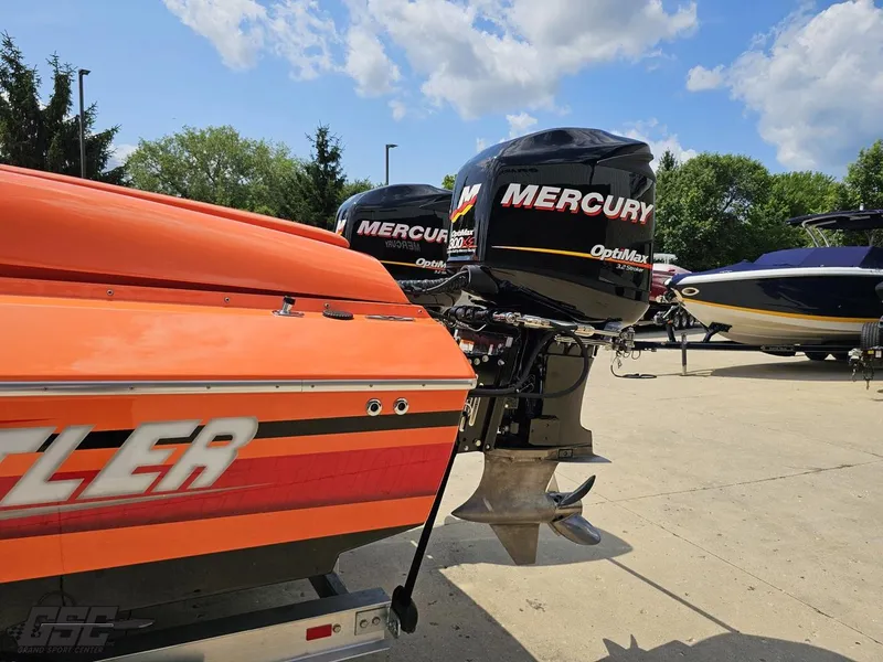 Slide: The Image of 2019 Hustler 25 Talon Cat with Mercury OptiMax engines, parked outdoors under a blue sky. - 37