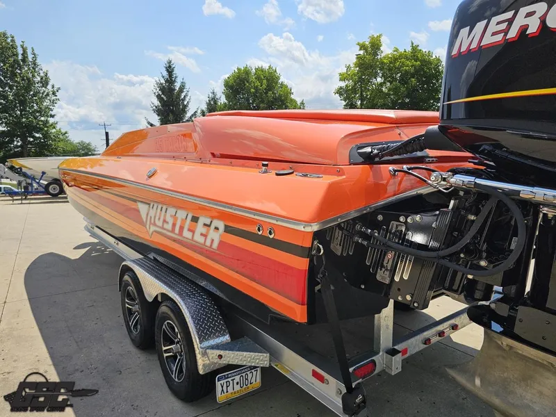 Slide: The Image of 2019 Hustler 25 Talon Cat boat in vibrant orange on a trailer, sunny day background. - 39