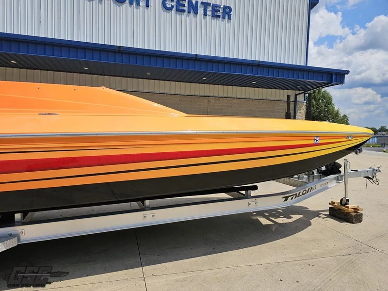 Slide: The Image of 2019 Hustler 25 Talon Cat boat with vibrant orange and red stripes on a trailer. - 7
