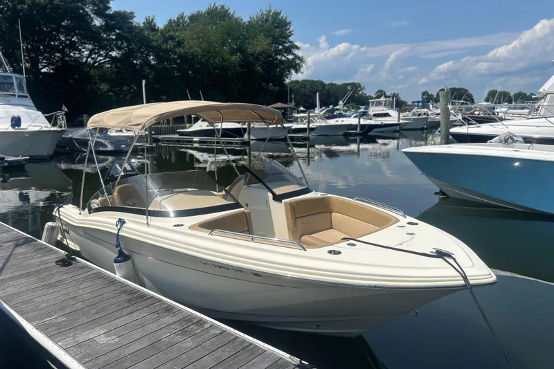 Slide: The Image of 2020 Scout 215 Dorado boat docked at a marina, surrounded by other boats. - 0