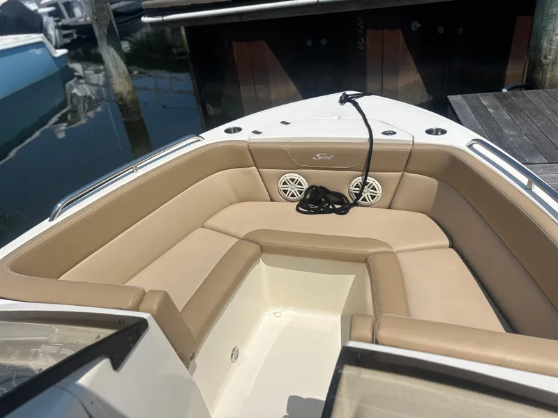 Slide: The Image of 2020 Scout 215 Dorado boat interior with tan seating and speakers at dock. - 2