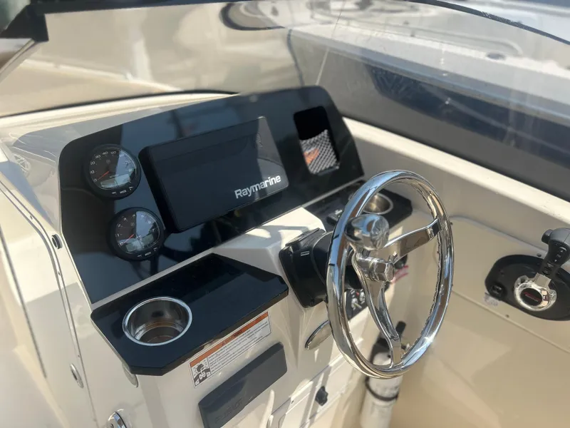 Slide: The Image of 2020 Scout 215 Dorado boat dashboard with Raymarine display and steering wheel. - 4