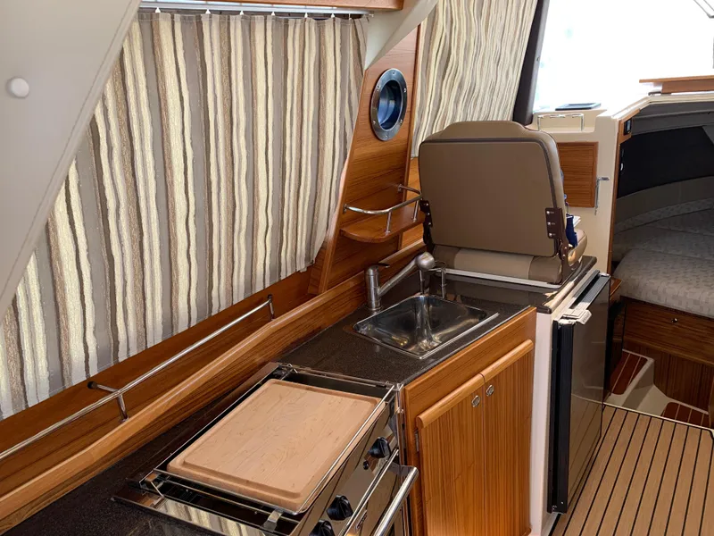 Slide: The Image of 2024 Ranger Tugs R-29 CB interior with kitchenette, sink, and seating area. - 13
