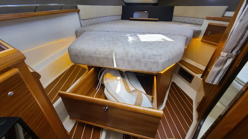 Slide: The Image of 2024 Ranger Tugs R-29 CB cabin interior with bed and storage drawer open. - 16