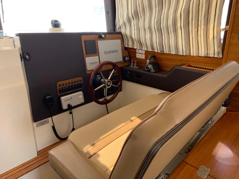 Slide: The Image of 2024 Ranger Tugs R-29 CB helm with Garmin navigation, leather seating, and wood accents. - 17