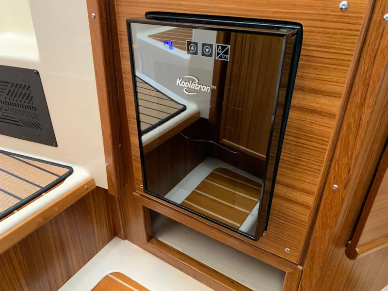 Slide: The Image of 2024 Ranger Tugs R-29 CB interior with Koolatron fridge, wood paneling, and modern design. - 19