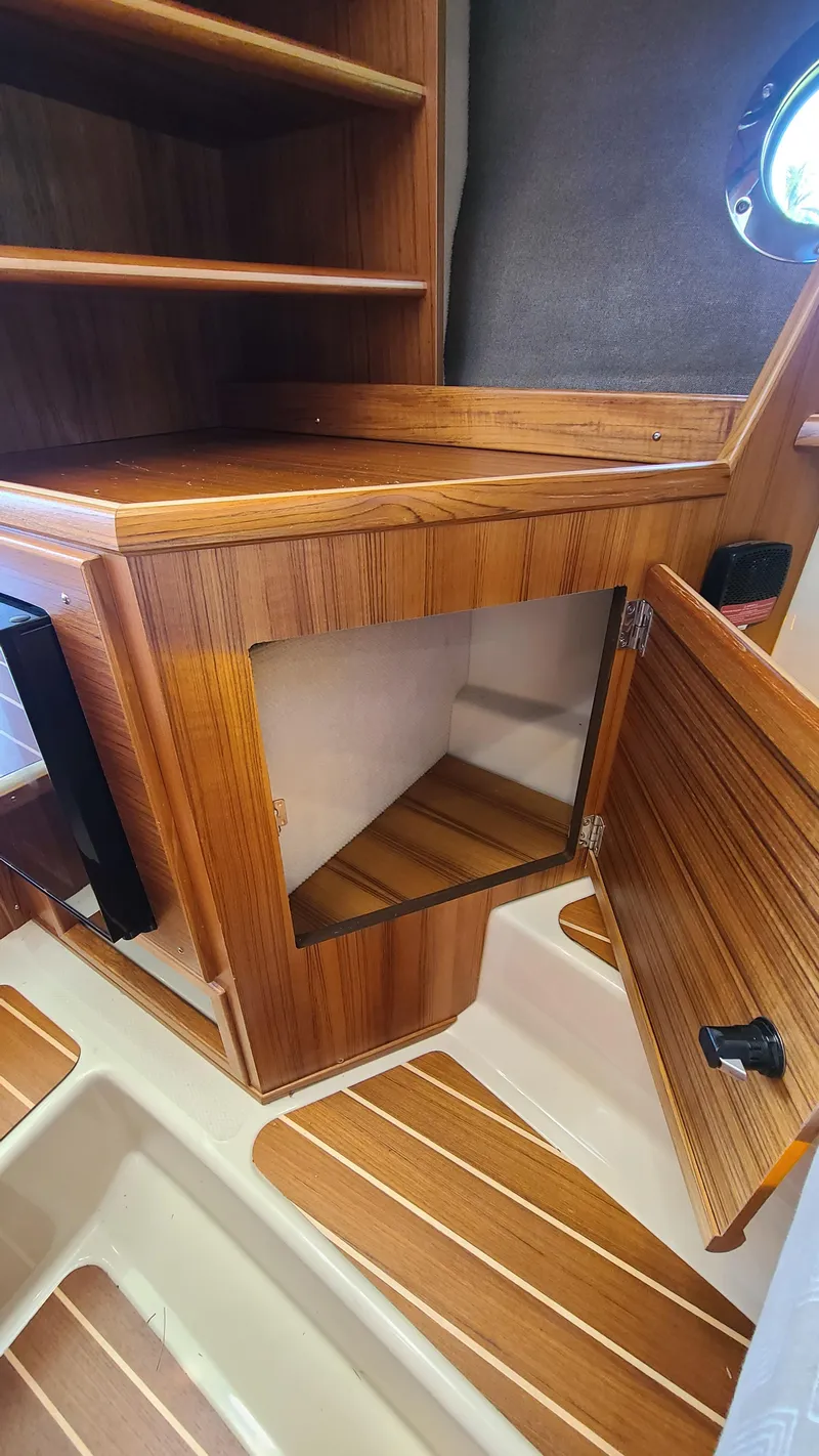 Slide: The Image of 2024 Ranger Tugs R-29 CB interior with wooden cabinetry and open storage space. - 20