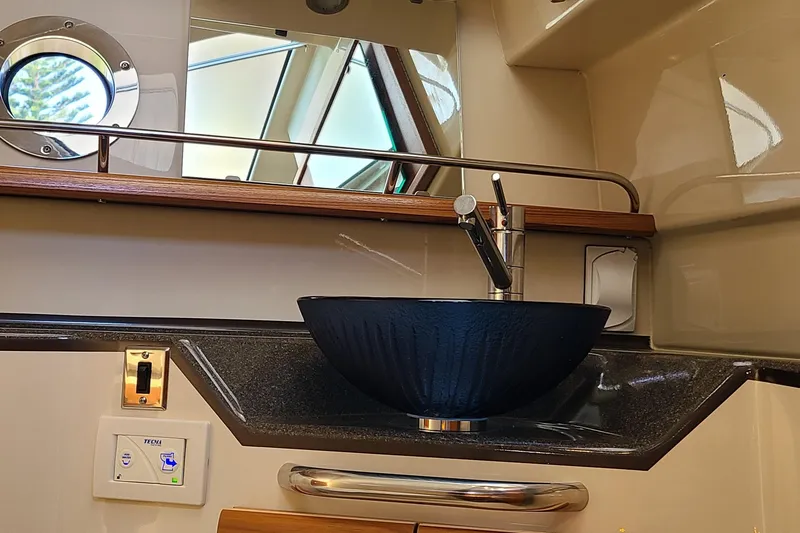 Slide: The Image of 2024 Ranger Tugs R-29 CB bathroom with modern sink and porthole window. - 23