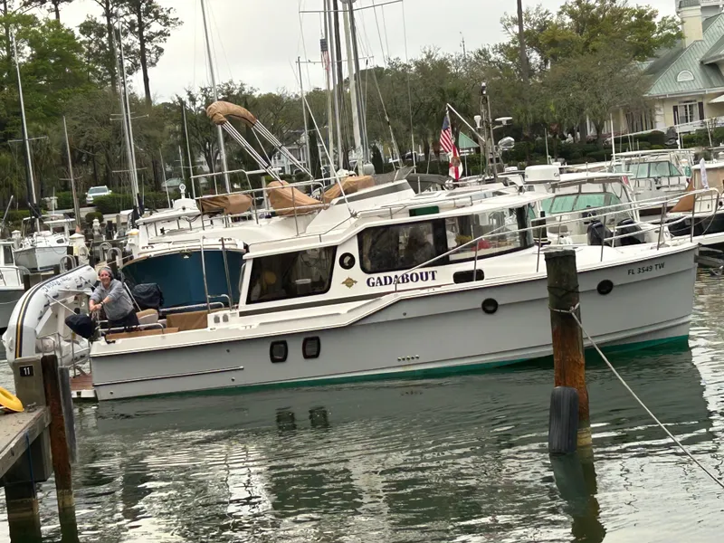 Slide: The Image of 2024 Ranger Tugs R-29 CB boat docked in a marina with a person onboard. - 3