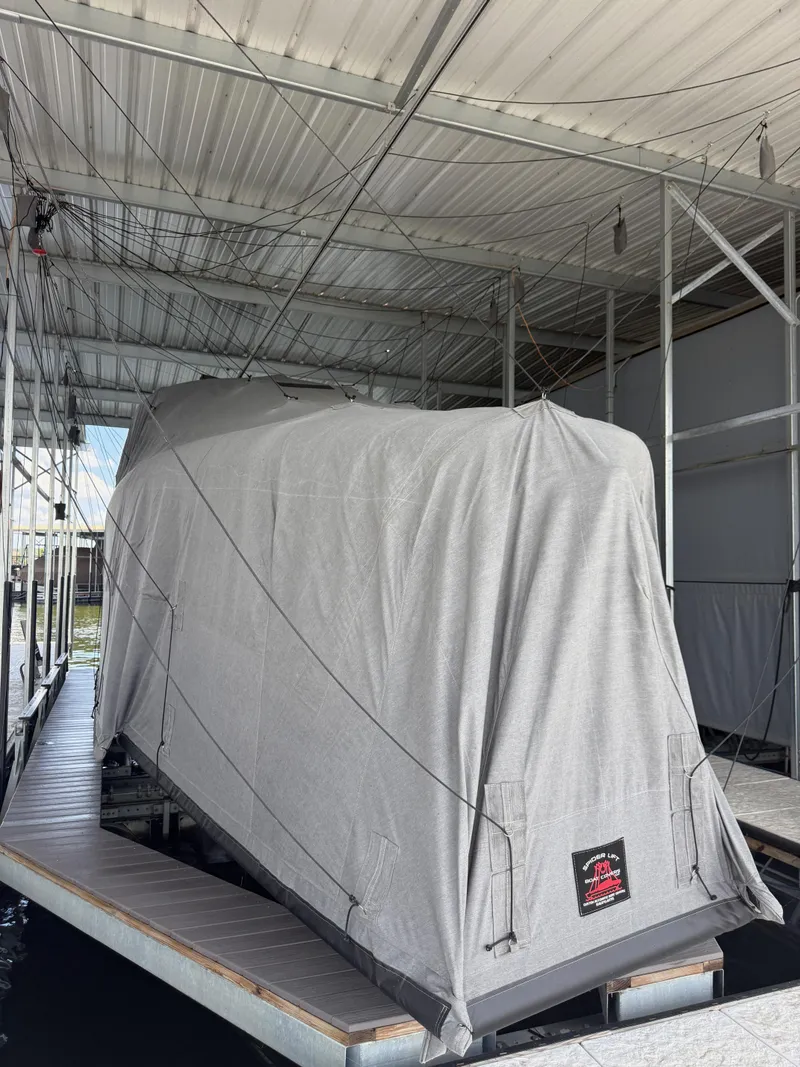 Slide: The Image of Covered 2025 Mystic Powerboats M4200 docked under shelter. - 12