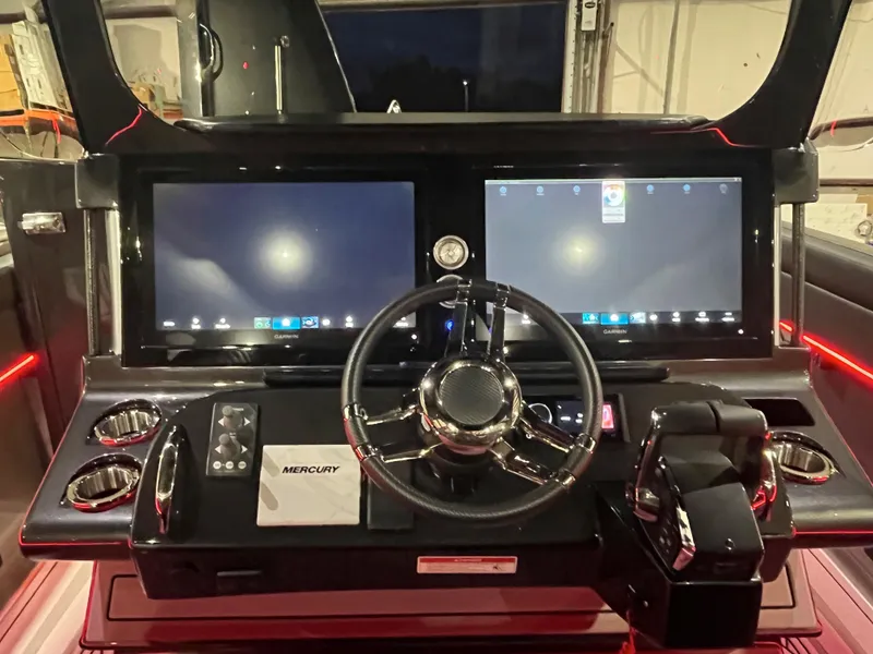 Slide: The Image of 2025 Mystic Powerboats M4200 helm with dual Garmin displays and Mercury controls. - 9