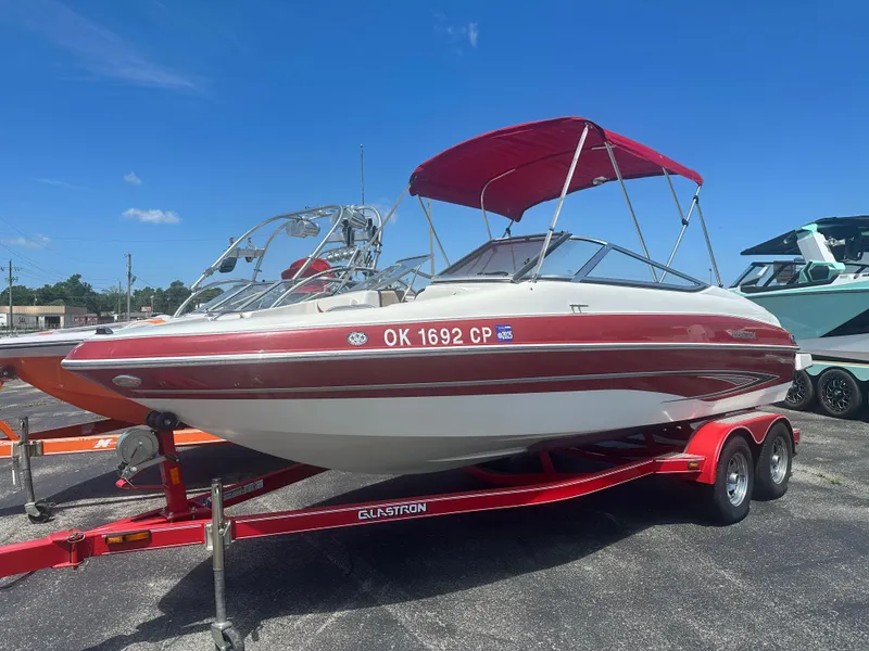 Slide: The Image of 2008 Glastron 205 GX boat with red canopy on trailer, parked outdoors. - 3