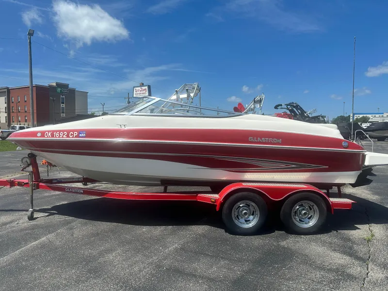 Slide: The Image of 2008 Glastron 205 GX boat on trailer, red and white design, parked outdoors. - 4