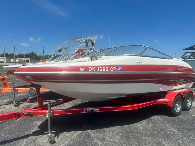 Slide: The Image of 2008 Glastron 205 GX boat on red trailer under clear blue sky. - 5
