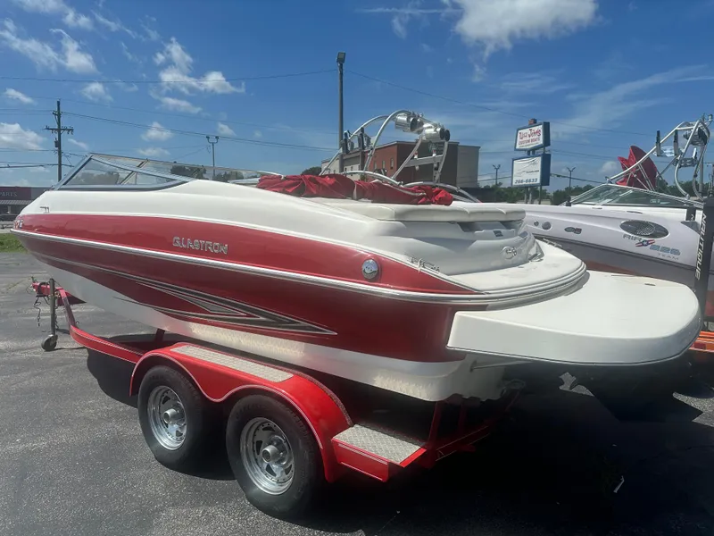 Slide: The Image of 2008 Glastron 205 GX boat on trailer, red and white design, parked outdoors under blue sky. - 6