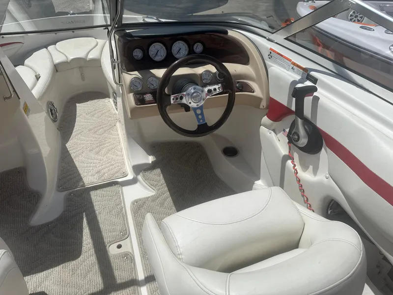 Slide: The Image of Interior of a 2008 Glastron 205 GX boat, featuring steering wheel and dashboard controls. - 9